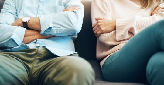 Man and woman sitting beside each other with arms crossed